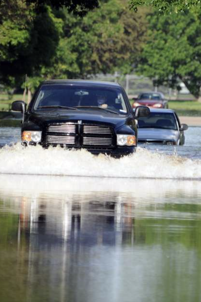 A truck driving into floodwater