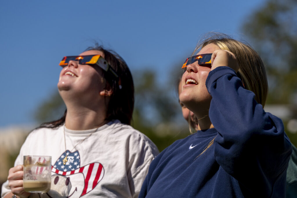 People viewing solar eclipse with glasses.